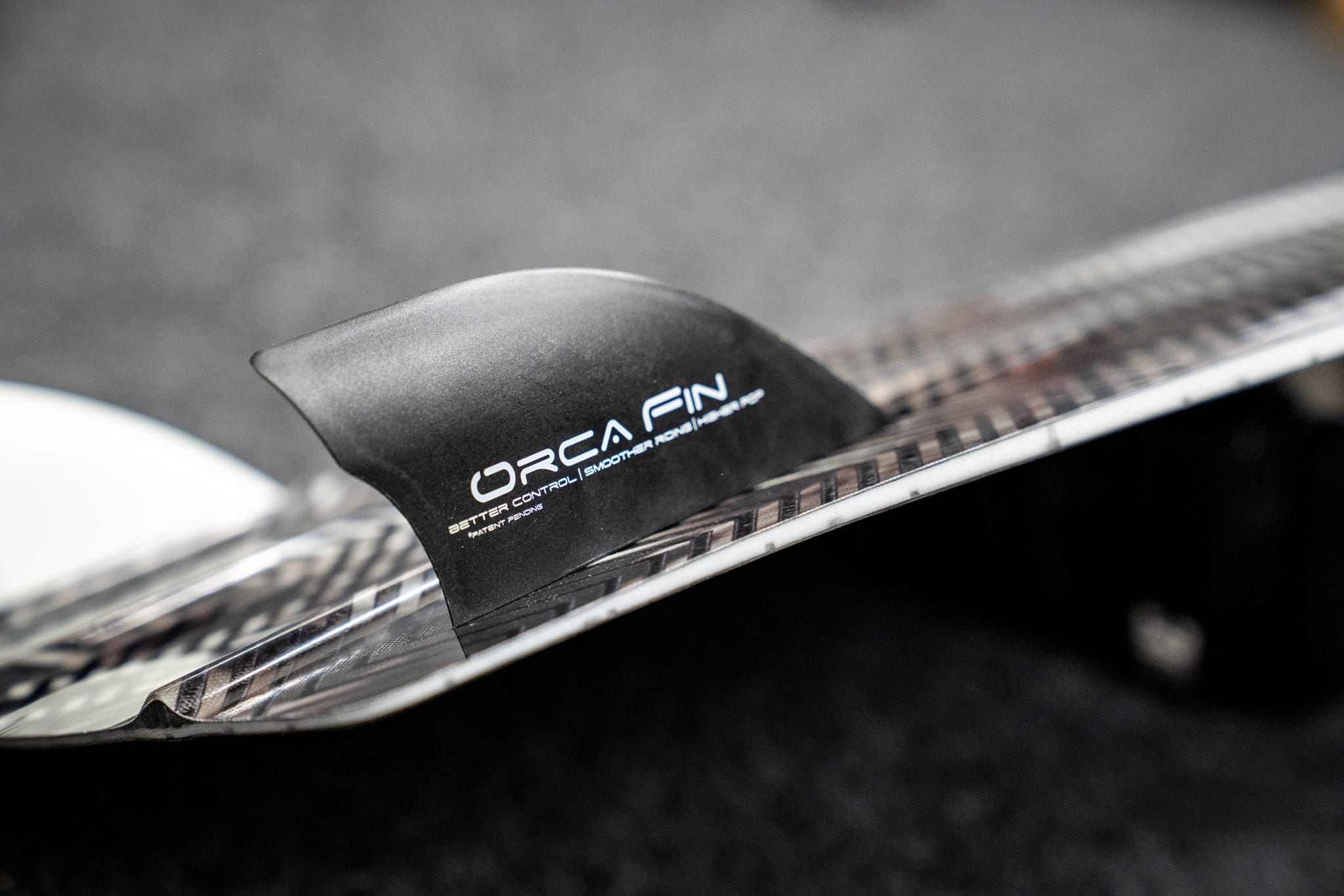 Orca Fins mounted on kiteboard rail for stronger heel-side edge